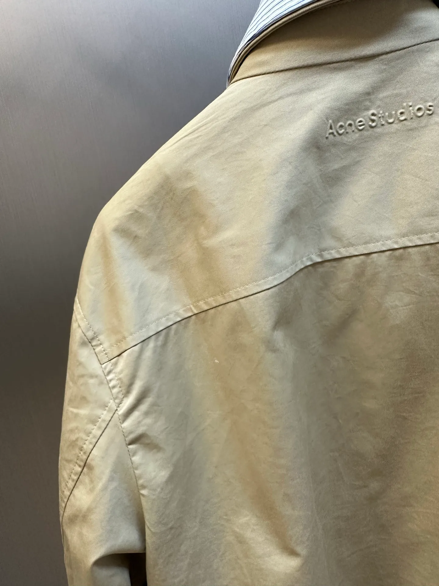 Ac Hot Sale genuine two-piece jacket. The main body is made of high-density twill cotton poplin. It has been processed by pre-shrunk washing process. The cloth surface is smooth and clean, with a matte and soft workwear texture. The stiffness is just right. The short version can be held up three-dimensionally and is not easy to collapse and wrinkle. It is suitable for daily commuting and outdoor use. The inner shirt is made of yarn-dyed blue and white striped cotton. The yarn-dyed stripes have clear texture and will not turn white or smudged after washing. The fabric surface is breathable and dry, and the collar and cuffs are folded and exposed to form contrasting color layers. The difficulty of the whole piece lies in the combined sewing of two fake pieces. The shirt collar and jacket collar are double-stitched and seamed. The collar corners are shaped and hemmed, and the folding shape is neat and will not collapse and curl. The placket adopts a double-layer structure of zipper + hidden buckle windproof fabric. The inner and outer layers of fabric are aligned and sewn together, and the wiring is even and fine. There are adjustable tabs on both sides of the hem, which can be freely tightened to suit different styles. The back printing adopts embossed relief technology, which blends into the fabric and is low-key and unobtrusive. The zipper is made of nylon zipper with metal teeth. The teeth are polished smoothly and will not get stuck after repeated pulling. The zipper headband has brand engraved details. The buttons are divided into two systems: the outer part is made of horn dark brown resin buttons with natural texture and high-end matte texture; the inner shirt is equipped with Cream White pearlescent four-eye buttons, echoing the blue and white striped fabric. size：xs s m l